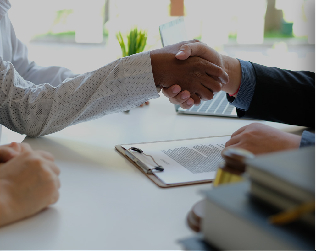 Couple meeting with lender and shaking hands.