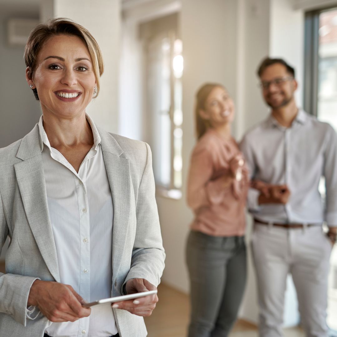 a smiling real estate agent with a couple