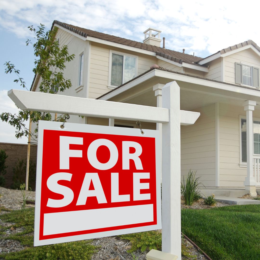 A for sale sign in front of a house